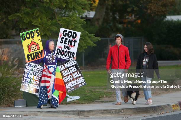 Claremont High School students Jack Safely with his dog "Tyke", and Michelle Schaeffer walk past Shirley Phelps-Roper, a member of Westboro Baptist...