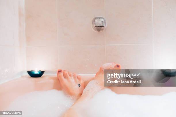 bubble bath first person perspective, woman's feet in bubble bath, woman in bath tub, bubble bath, indulgence, bubbles, tub, bath first person perspective - hot pink stockfoto's en -beelden