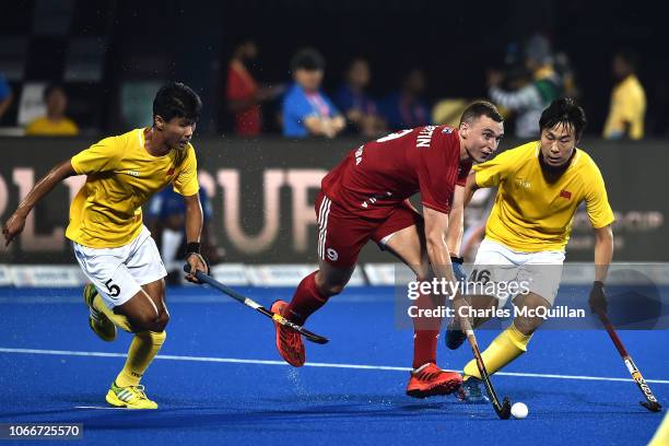 Harry Martin of England is tackled by Jun Su and Quyang Guan of China during the FIH Men's Hockey World Cup Group B match between England and China...