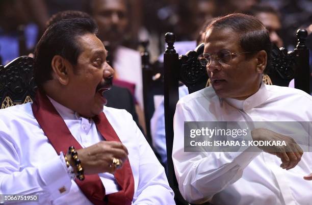 Sri Lankas President Maithripala Sirisena speaks with former president and currently appointed prime minister Mahinda Rajapaksa at a ceremony...