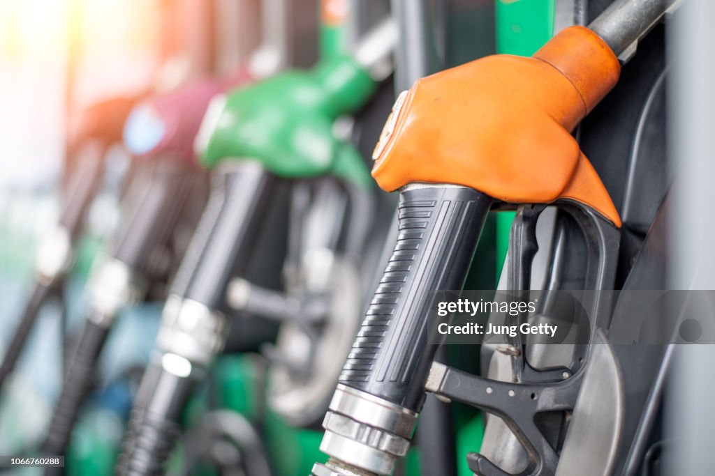 Pumping equipment gas at gas station. Close up of a hand holding fuel nozzle