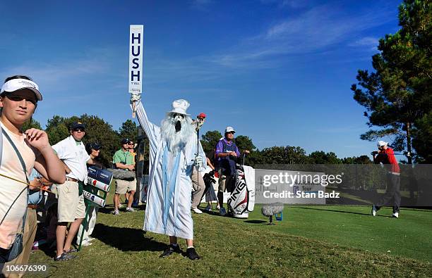James Hahn, far right, hits a drive as a hole marshal dressed in a halloween costume stands at the 18th tee box during the third round of the...