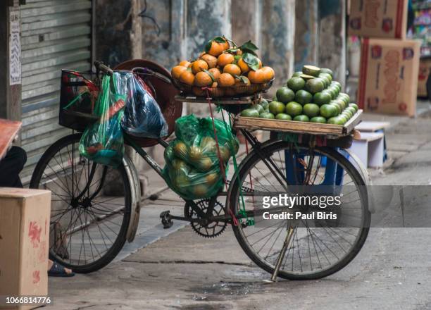 old bicycle with oranges fruits on street market in hanoi, vietnam - vietnamese street food stock pictures, royalty-free photos & images