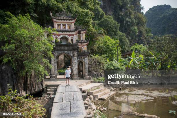 boy walking near the chinese style gate, bich dong pagoda in ninh binh, vietnam - vietnam wall stock pictures, royalty-free photos & images