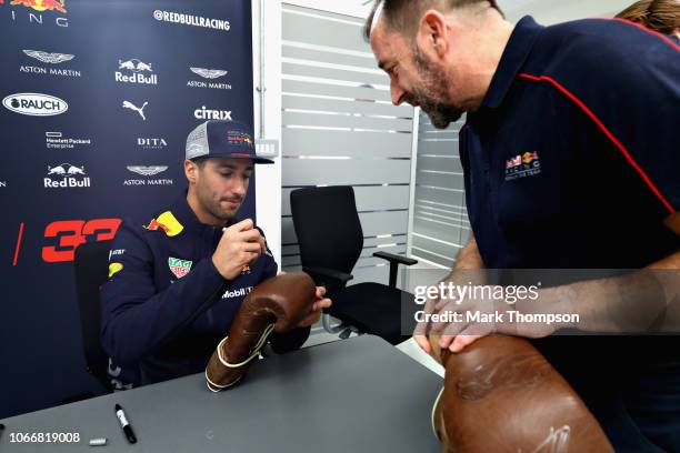 Daniel Ricciardo of Australia and Red Bull Racing signs autographs during the Red Bull Racing Drivers Factory Visit at Red Bull Racing Factory on...