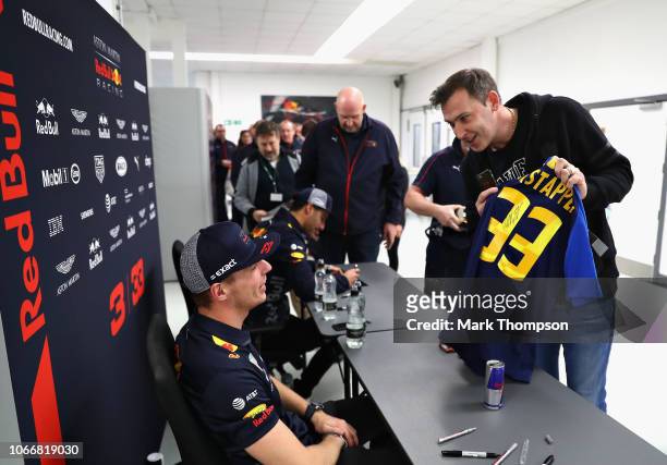 Max Verstappen of Netherlands and Red Bull Racing and Daniel Ricciardo of Australia and Red Bull Racing talk with Red Bull Racing team members during...