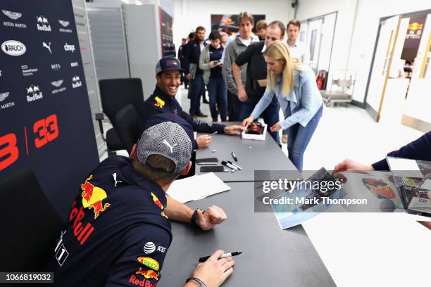 Max Verstappen of Netherlands and Red Bull Racing and Daniel Ricciardo of Australia and Red Bull Racing talk with Red Bull Racing team members during...