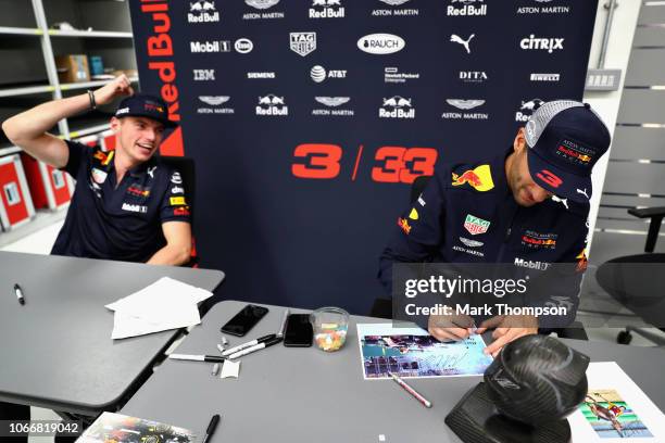 Max Verstappen of Netherlands and Red Bull Racing and Daniel Ricciardo of Australia and Red Bull Racing sign autographs during the Red Bull Racing...