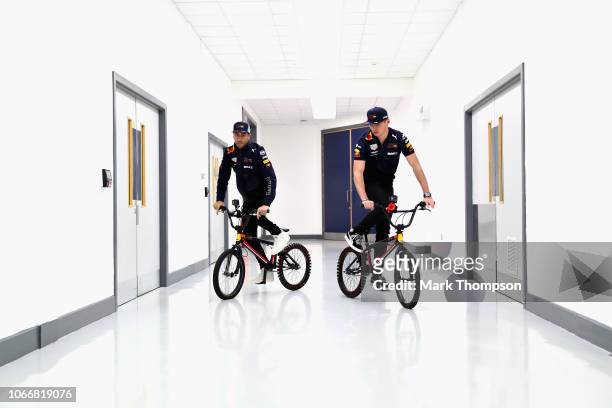 Max Verstappen of Netherlands and Red Bull Racing and Daniel Ricciardo of Australia and Red Bull Racing ride bikes in the factory during the Red Bull...