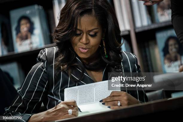 Former U.S. First Lady Michelle Obama signs copies of her new book 'Becoming' during a book signing event at a Barnes & Noble bookstore, November 30,...