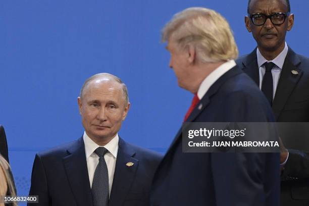 President Donald Trump, looks at Russia's President Vladimir Putin as they take place for a family photo, during the G20 Leaders' Summit in Buenos...