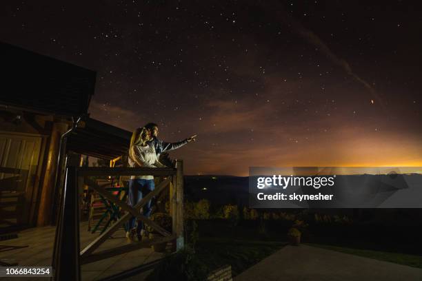 honey, blick in die sterne! - couple balcony stock-fotos und bilder