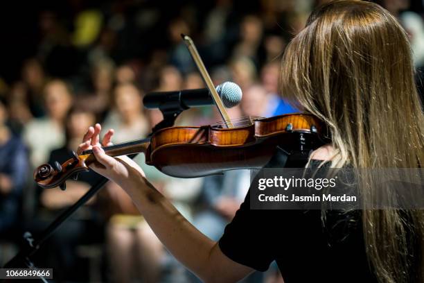 girl playing the violin in concert hall - music halls fotografías e imágenes de stock