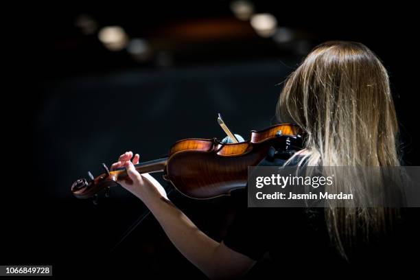 girl playing the violin in concert hall - musical instrument stock-fotos und bilder