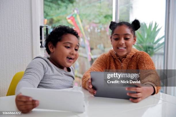 brother and sister smiling and using digital devices - www stock pictures, royalty-free photos & images