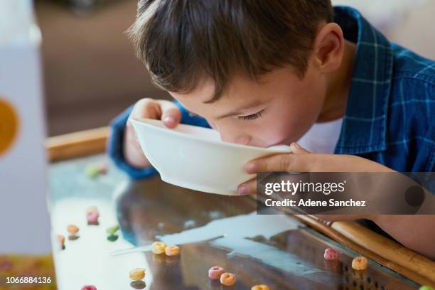 when the cereal makes the milk taste like milkshake - boy eating cereal stock pictures, royalty-free photos & images