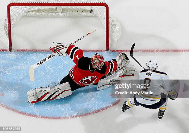 Derek Roy of the Buffalo Sabres puts the puck into the top right corner of the net against goaltender Johan Hedberg of the New Jersey Devils for the...