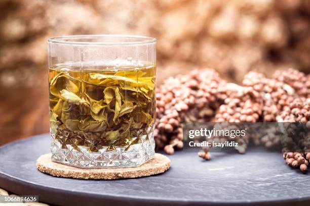 a cup of herbal tea - green tea leaves stock pictures, royalty-free photos & images
