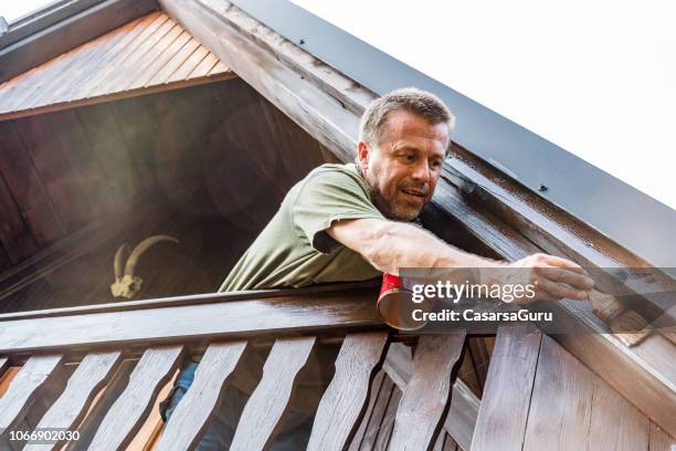 adult man enjoying renovating a cottage - roof beam stock pictures, royalty-free photos & images