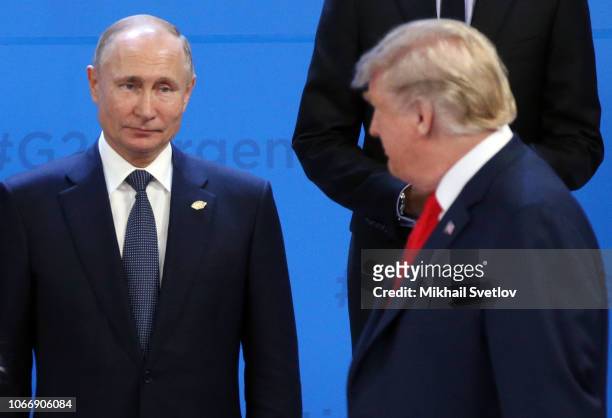 President Donald Trump looks on Russian President Vladimir Putin during the family photo at the G20 Summit's Plenary Meeting in Buenos Aires,...