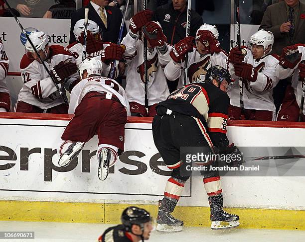 Bryan Bickell of the Chicago Blackhawks knocks Derek Morris of the Phoenix Coyotes over the wall and into the Coyote bench at the United Center on...