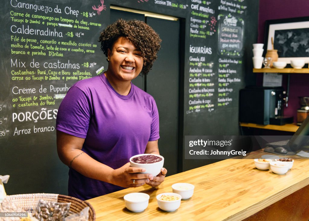 Cheerful Brazilian woman behind counter in açai cafe