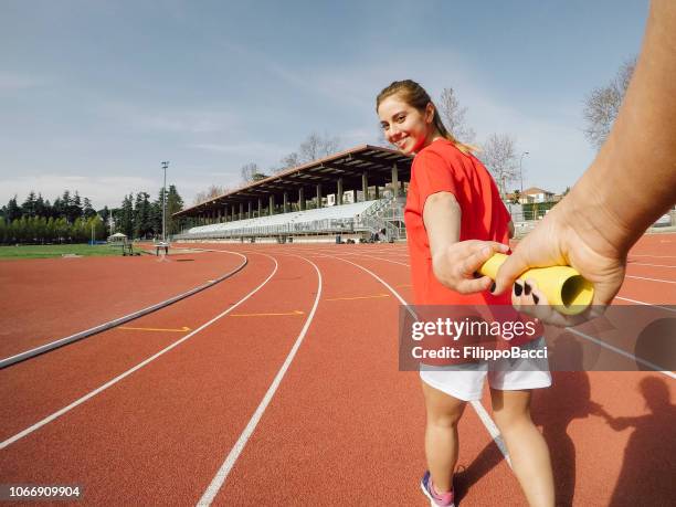 de estafette stokje doorgeven aan het nummer veld - doorgeven stockfoto's en -beelden