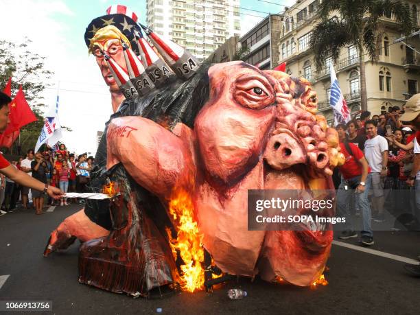 Protester seen lighting fire on an effigy of President Duterte during the protest. Leftist groups stage Bonifacio Day of protest in Mendiola and at...