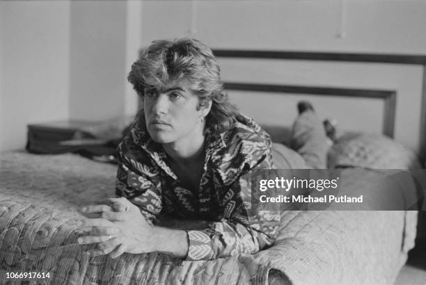 British singer-songwriter George Michael of Wham! posed lying on a bed in a Sydney hotel room during the Australian leg of the pop duo's 1985 world...