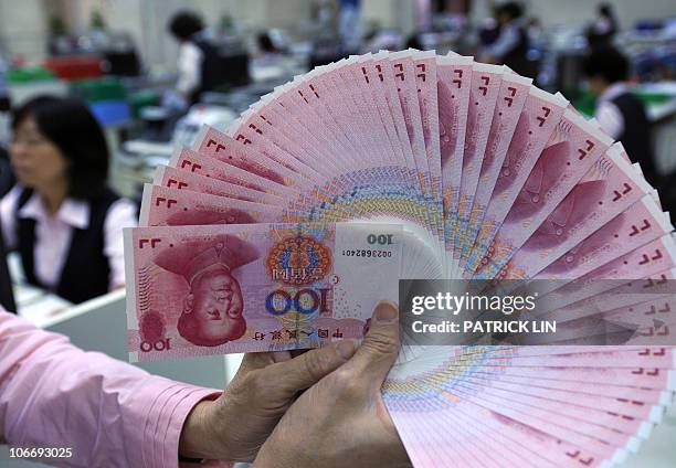 Clerk counts Chinese renminbi bills at a bank in Taipei on November 11, 2010. World leaders on November 11 start two days of summit talks dominated...