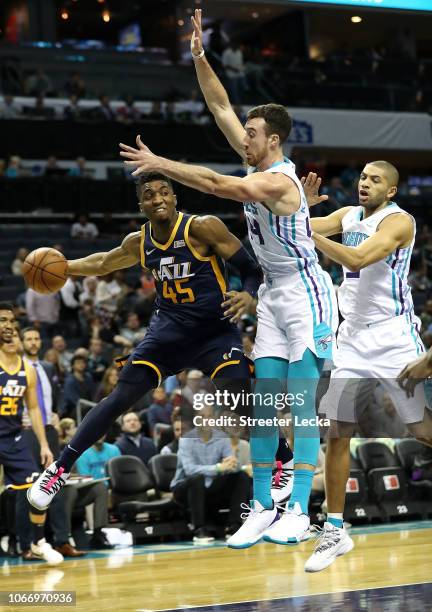 Donovan Mitchell of the Utah Jazz looks to pass around teammates Frank Kaminsky and Nicolas Batum of the Charlotte Hornets during their game at...