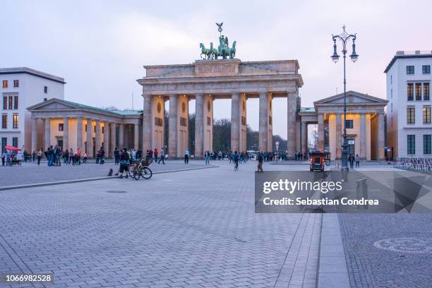 brandenburg gate illuminated at night,neue wache building,  evening sky, berlin, germany - neue wache berlin stock-fotos und bilder