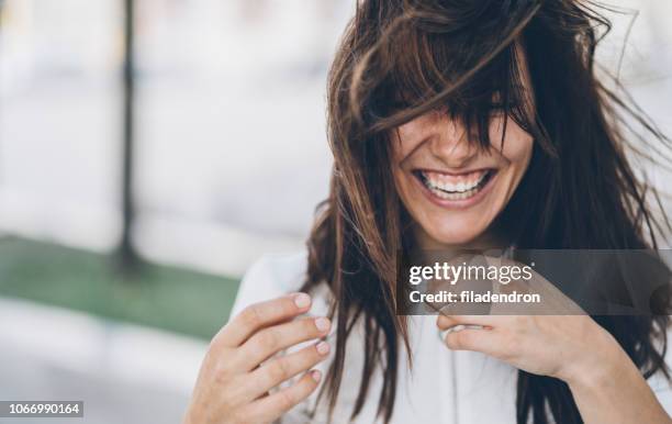 lachende vrouw op een winderige dag - stralende lach stockfoto's en -beelden