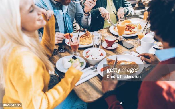 multi ethnic group of friends eating lunch in a restaurant - brunch imagens e fotografias de stock