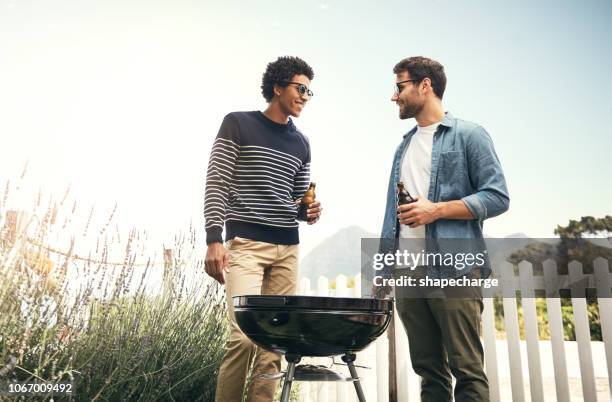 the best conversations are had around the barbecue - couple grilling stock pictures, royalty-free photos & images