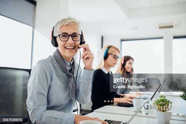 smiling mature call center worker - switchboard operator stock pictures, royalty-free photos & images