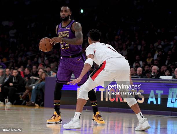 LeBron James of the Los Angeles Lakers directs a play in front of Evan Turner of the Portland Trail Blazers at Staples Center on November 14, 2018 in...