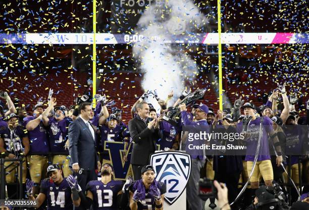 Head coach Chris Petersen of the Washington Huskies is given the championship trophy after the Huskies beat the Utah Utes to win the Pac 12...