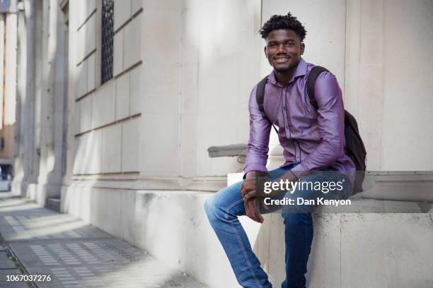 young african man in city - purple shirt stock-fotos und bilder