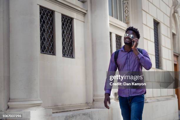 young african man in city - mirrored sunglasses stock-fotos und bilder