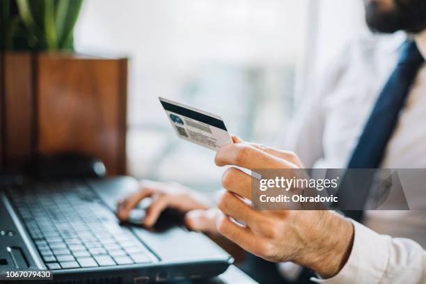 オンライン クレジット カードを持っている男性の手を閉じる - business cards ストックフォトと画像