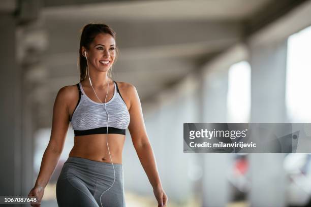 smiling woman resting after workout - sportswear stock pictures, royalty-free photos & images