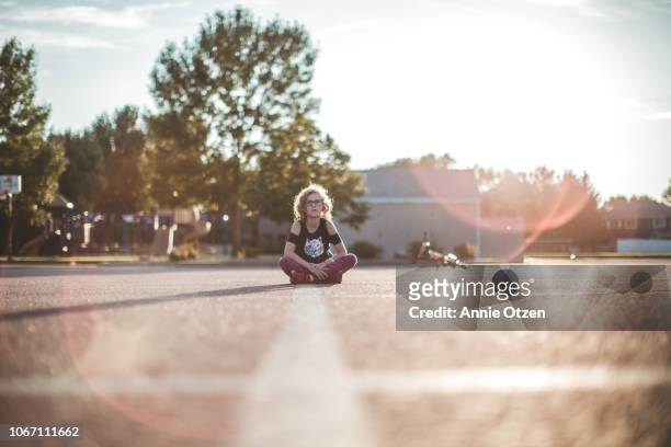 girl sitting in middle of parking lot - center street elementary - fotografias e filmes do acervo