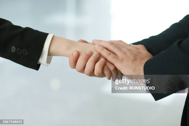 two mourners holding hands - crematorium imagens e fotografias de stock