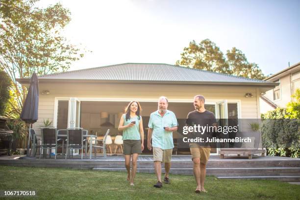 time-out voor de volwassenen, lopen door de tuin met een drankje in de hand - australian family time stockfoto's en -beelden