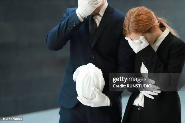 bereaved mourning at funeral - funeral urn stock pictures, royalty-free photos & images