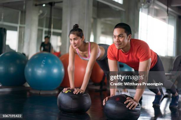 doing stretching exercises on fitness ball in gym. - gymnastic asian stockfoto's en -beelden