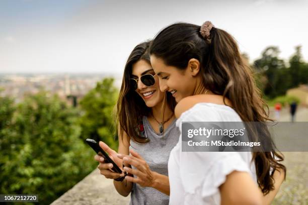 utilizando el teléfono móvil. - amistad femenina fotografías e imágenes de stock