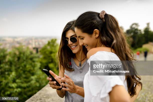 using mobile phone. - female friendship stock pictures, royalty-free photos & images