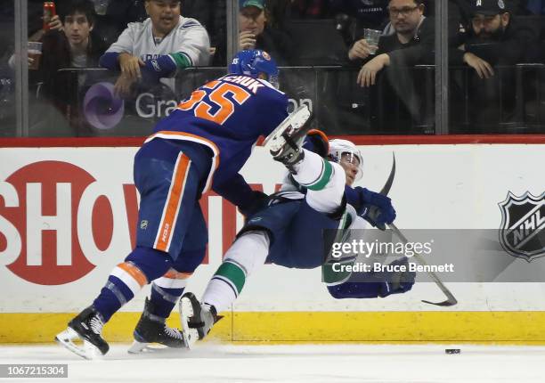 Johnny Boychuk of the New York Islanders checks Markus Granlund of the Vancouver Canucks during the second period at the Barclays Center on November...